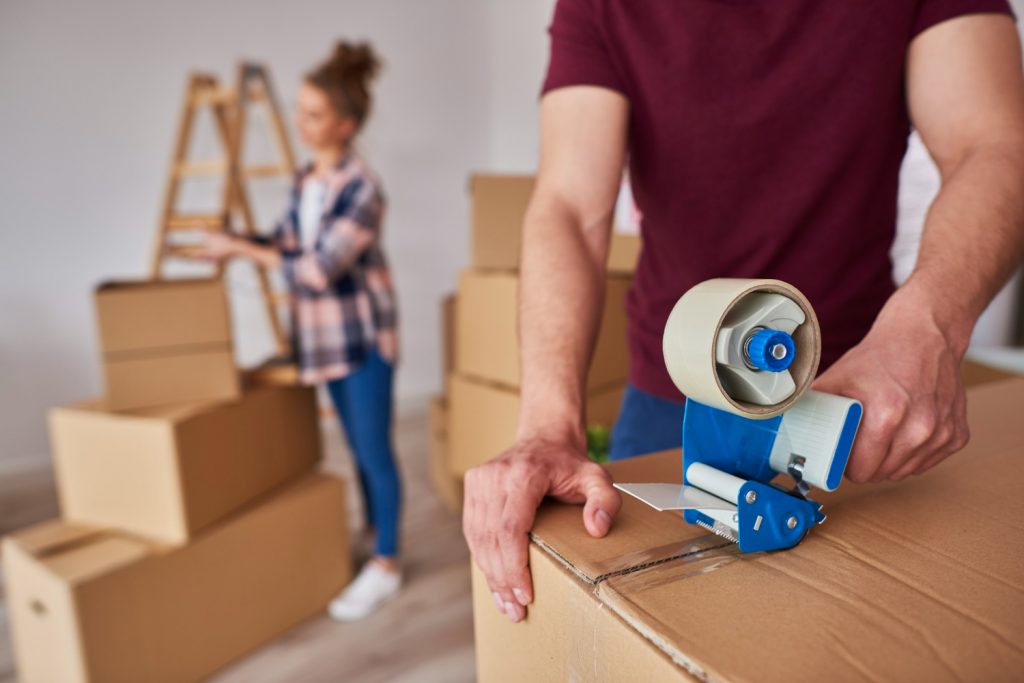 Is It Cheaper to Move Yourself or Hire a Removal Company? 2 Taping up Boxes
